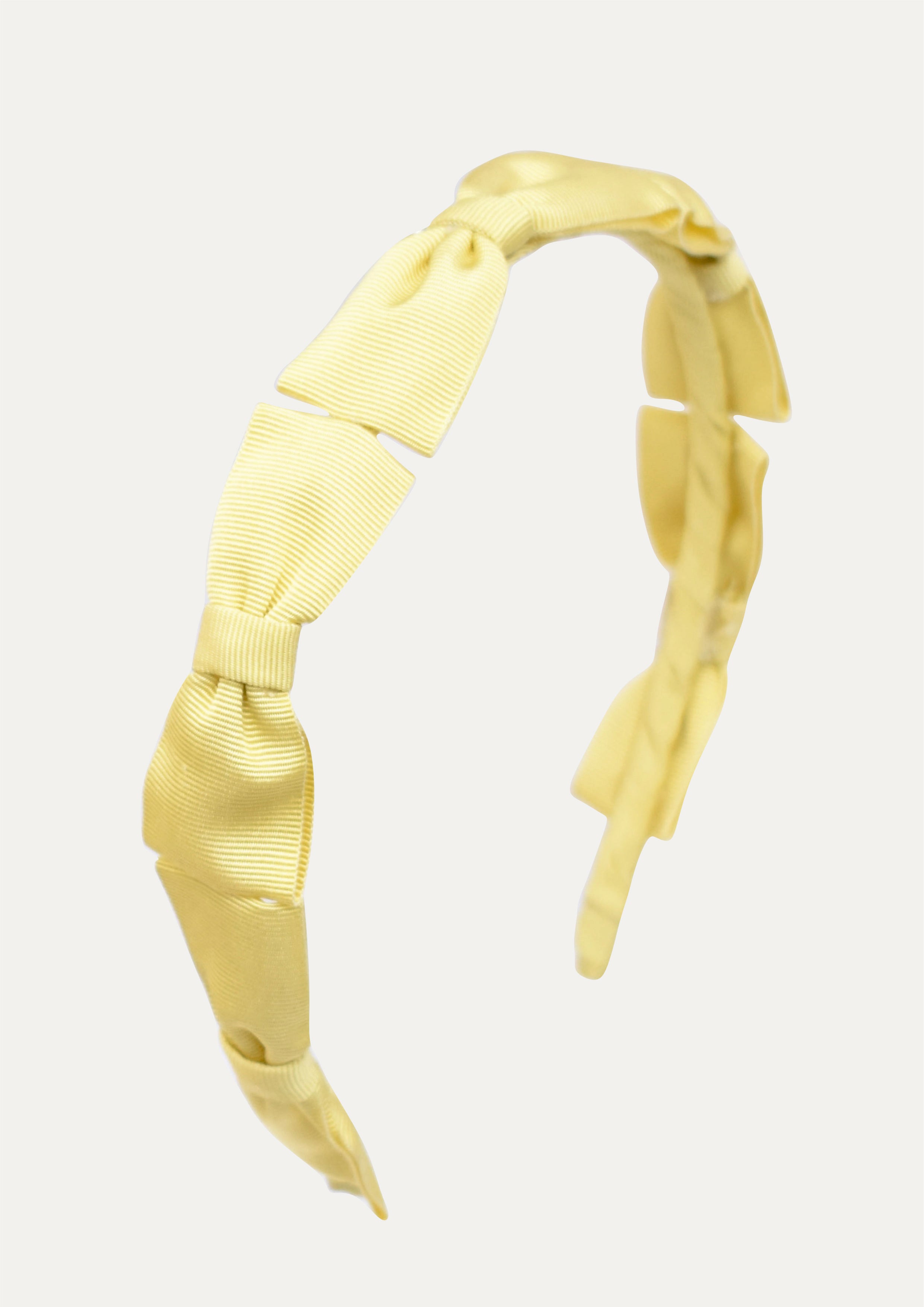 Handmade sunny yellow headband for girls featuring a row of five small grosgrain ribbon bows.