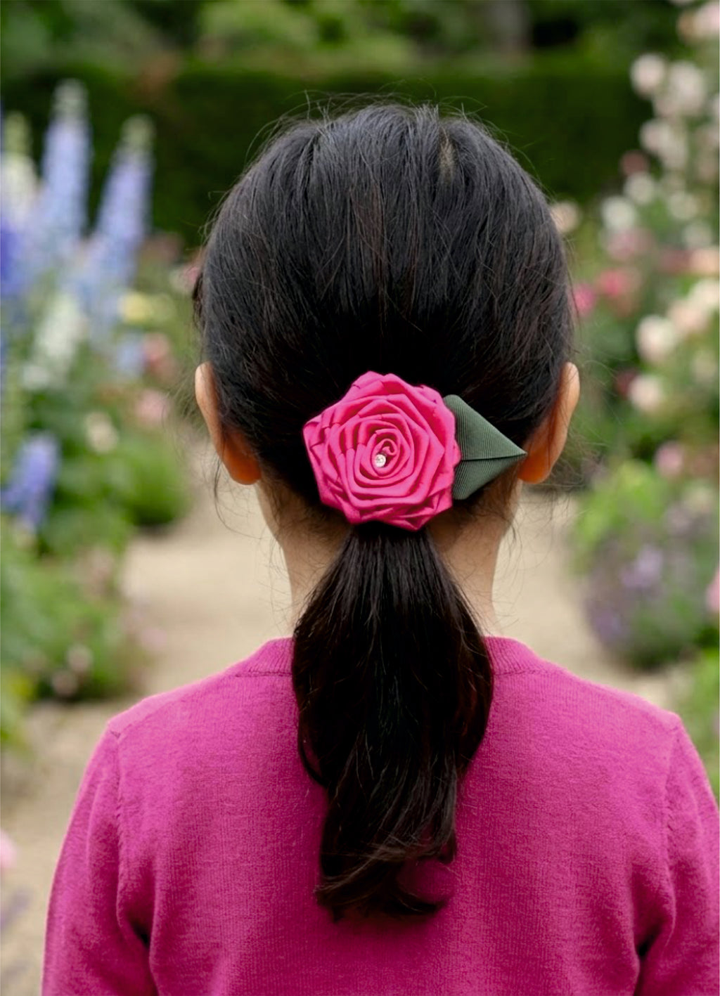Girl wearing pink rose floral hair tie in ponytail